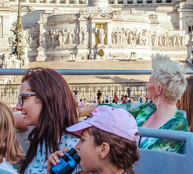 Tourists on Green Line Rome Hop-on Hop-off bus near Colosseum, Rome, Italy.