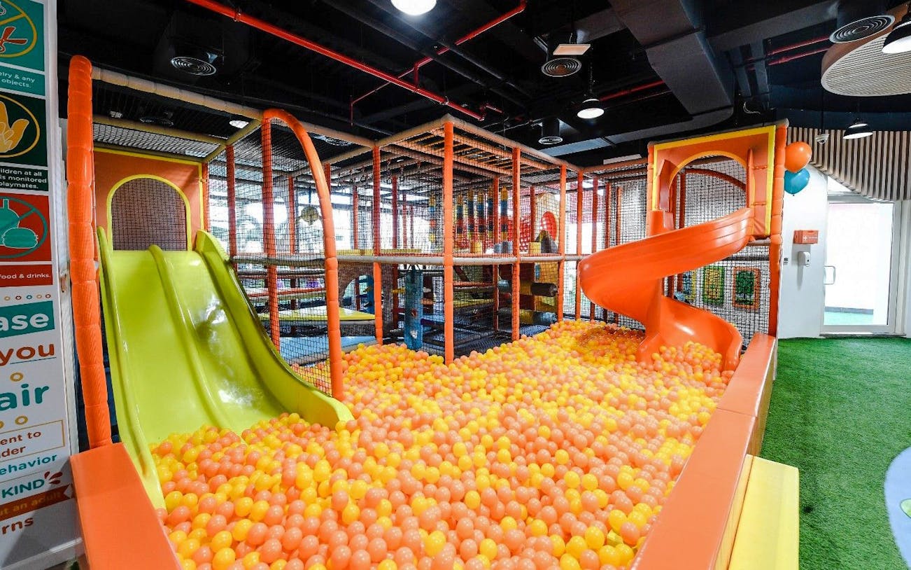 Soft play area with slides and ball pit at Orange Wheels, Global Village, Dubai.