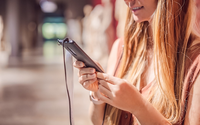 Woman using phone audio guide in a museum.