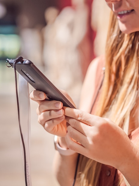 Woman using phone audio guide in a museum.