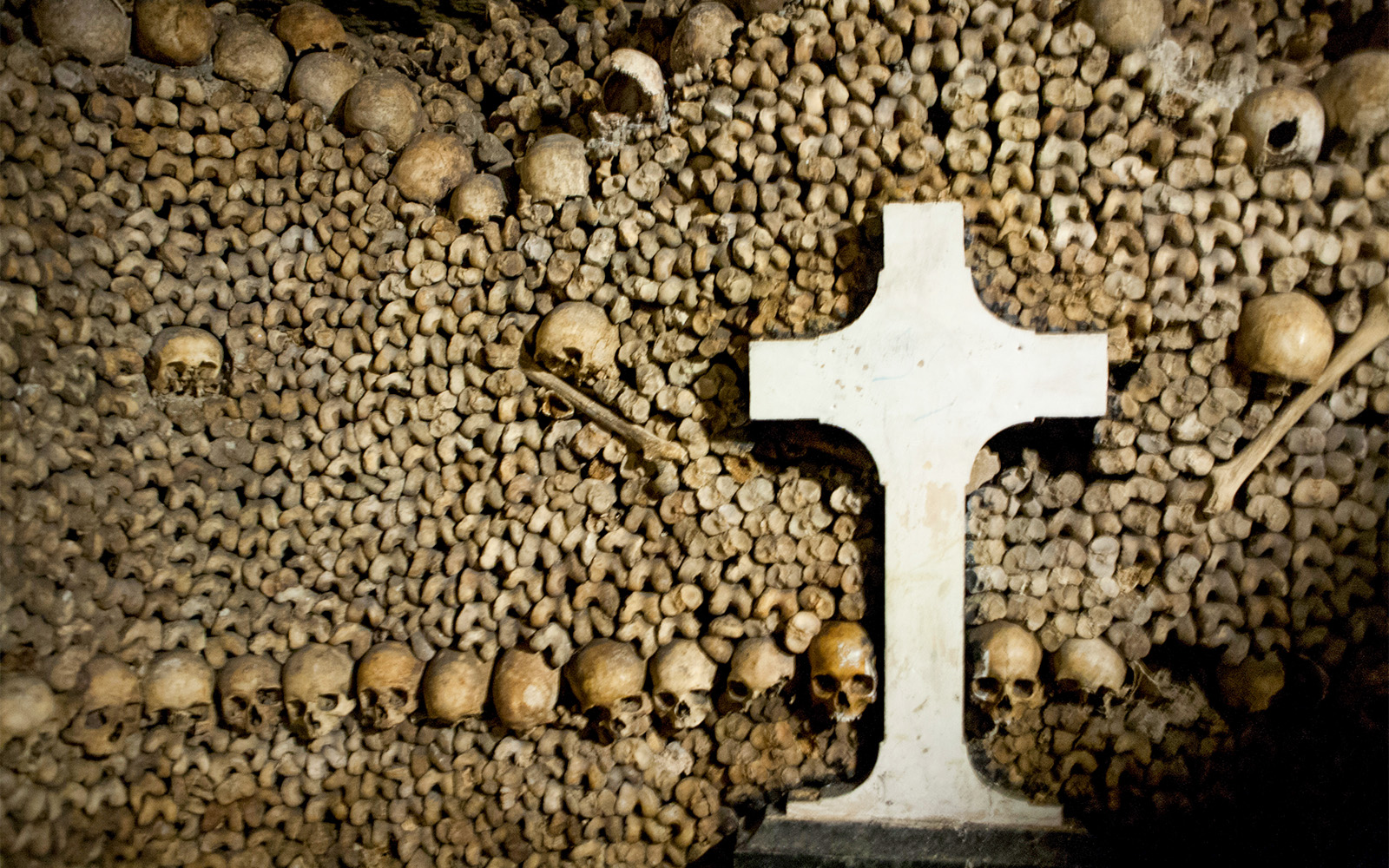 Skulls and bones arranged around a cross in the Paris Catacombs.
