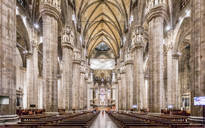 Duomo Milan Cathedral interior with tourists on guided tour, Italy.
