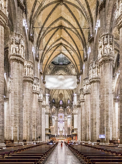Duomo Milan Cathedral interior with tourists on guided tour, Italy.