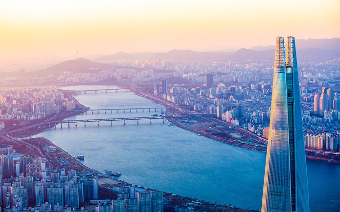 Lotte World Tower overlooking Han River in Seoul at sunset.