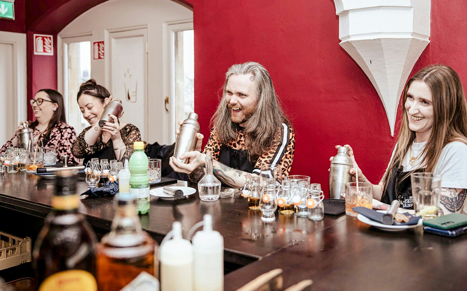 Participants shaking cocktail shakers at the Irish Whiskey Museum masterclass.