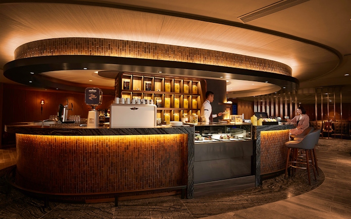 First-class lounge bar at Hong Kong International Airport with seating and refreshments.