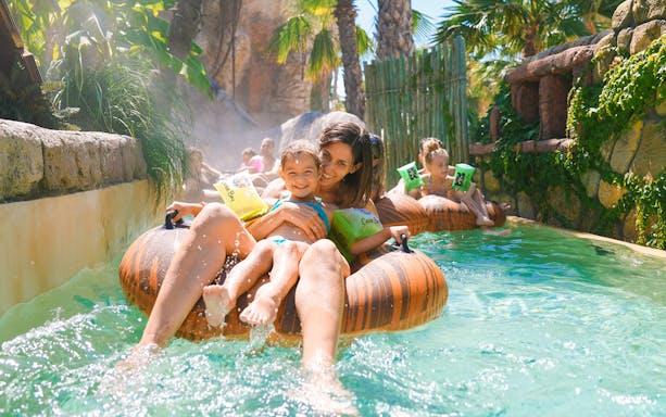Tourists enjoying lazy river ride at Caribe Bay water park.