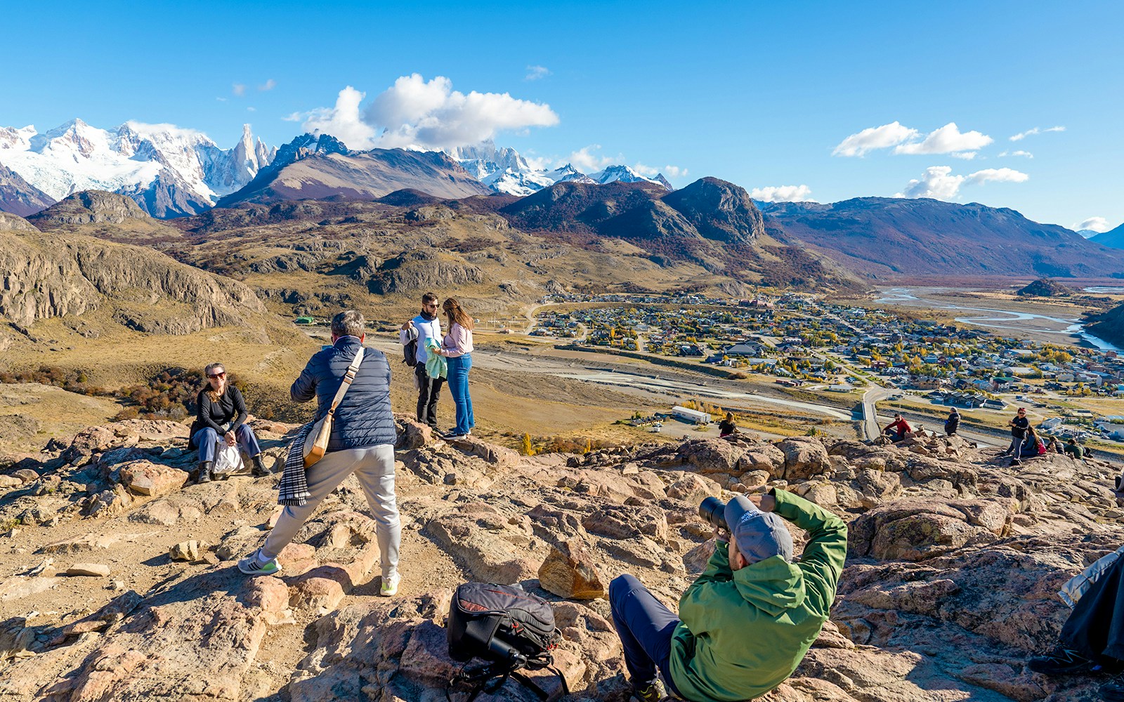 Tourists on a hiking trail overlooking El Chaltén village and mountains in Santa Cruz, Argentina.