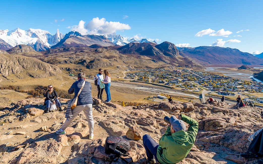 Tourists on a hiking trail overlooking El Chaltén village and mountains in Santa Cruz, Argentina.