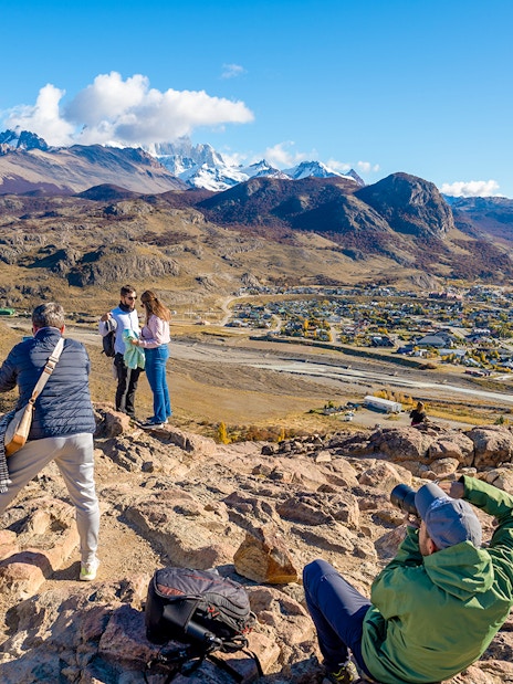 Tourists on a hiking trail overlooking El Chaltén village and mountains in Santa Cruz, Argentina.