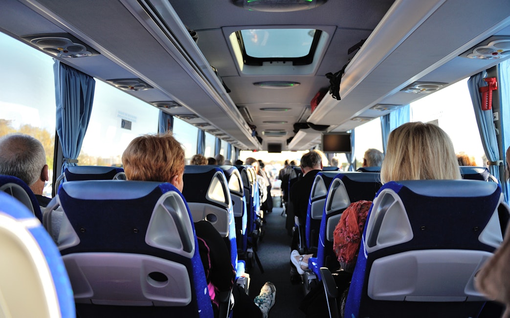 Tourists seated inside a bus touring Washington D.C. monuments.