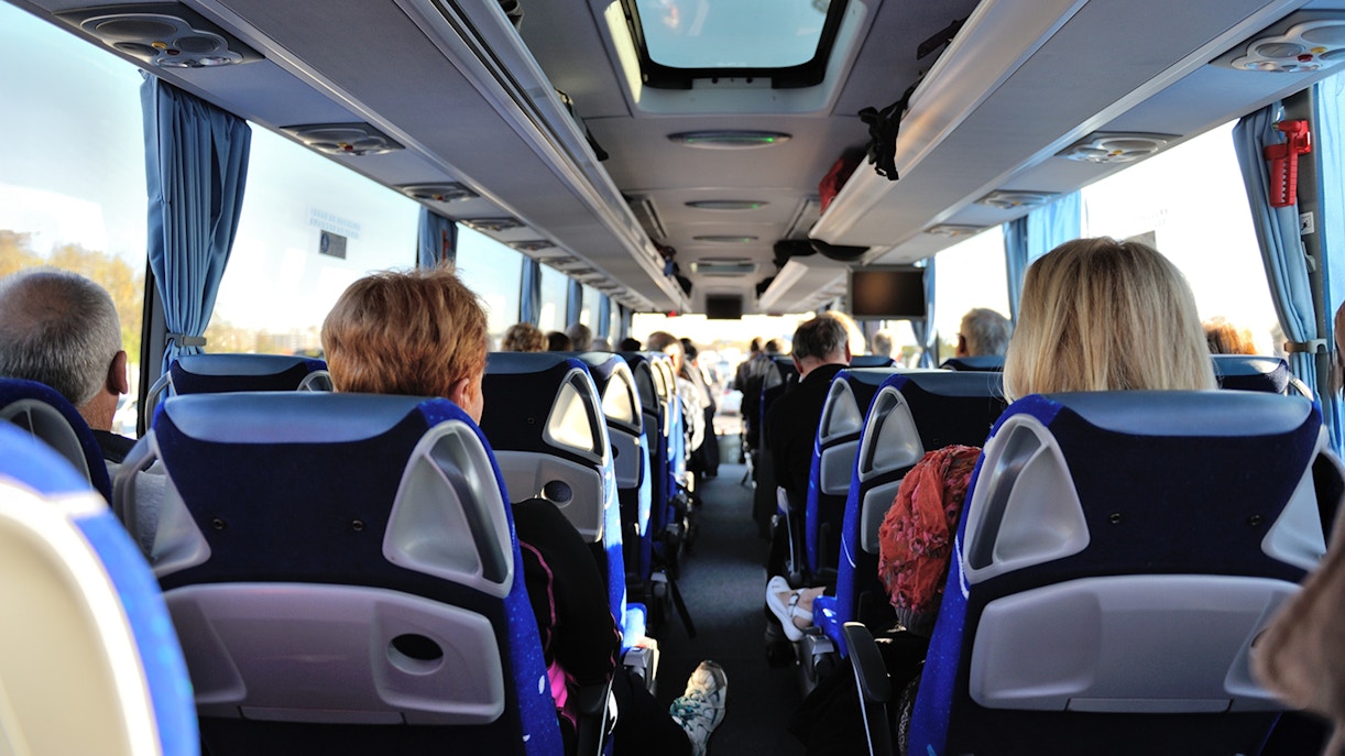 Tourists seated inside a bus touring Washington D.C. monuments.
