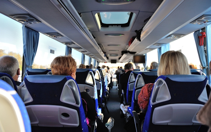Tourists seated inside a bus touring Washington D.C. monuments.