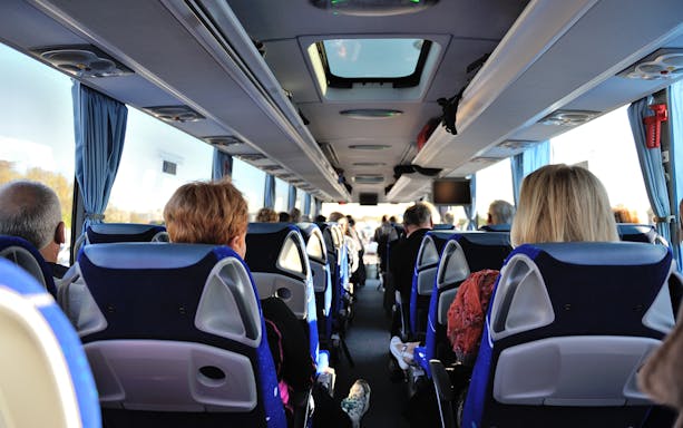Tourists seated inside a bus touring Washington D.C. monuments.