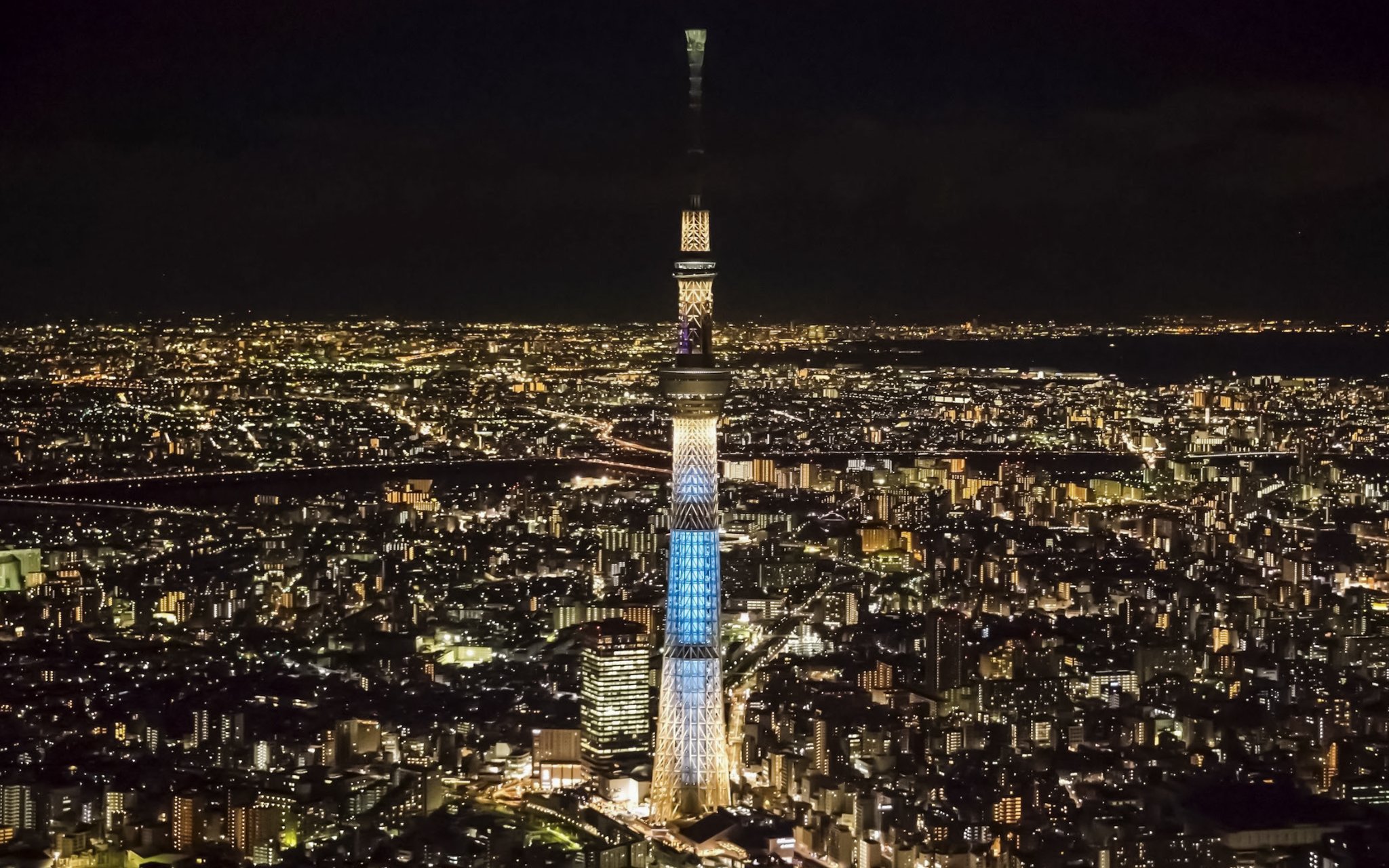 Tokyo Skytree illuminated at night, towering over the cityscape.