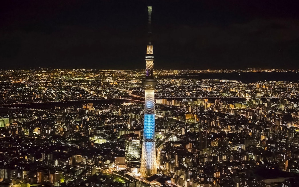 Tokyo Skytree illuminated at night, towering over the cityscape.