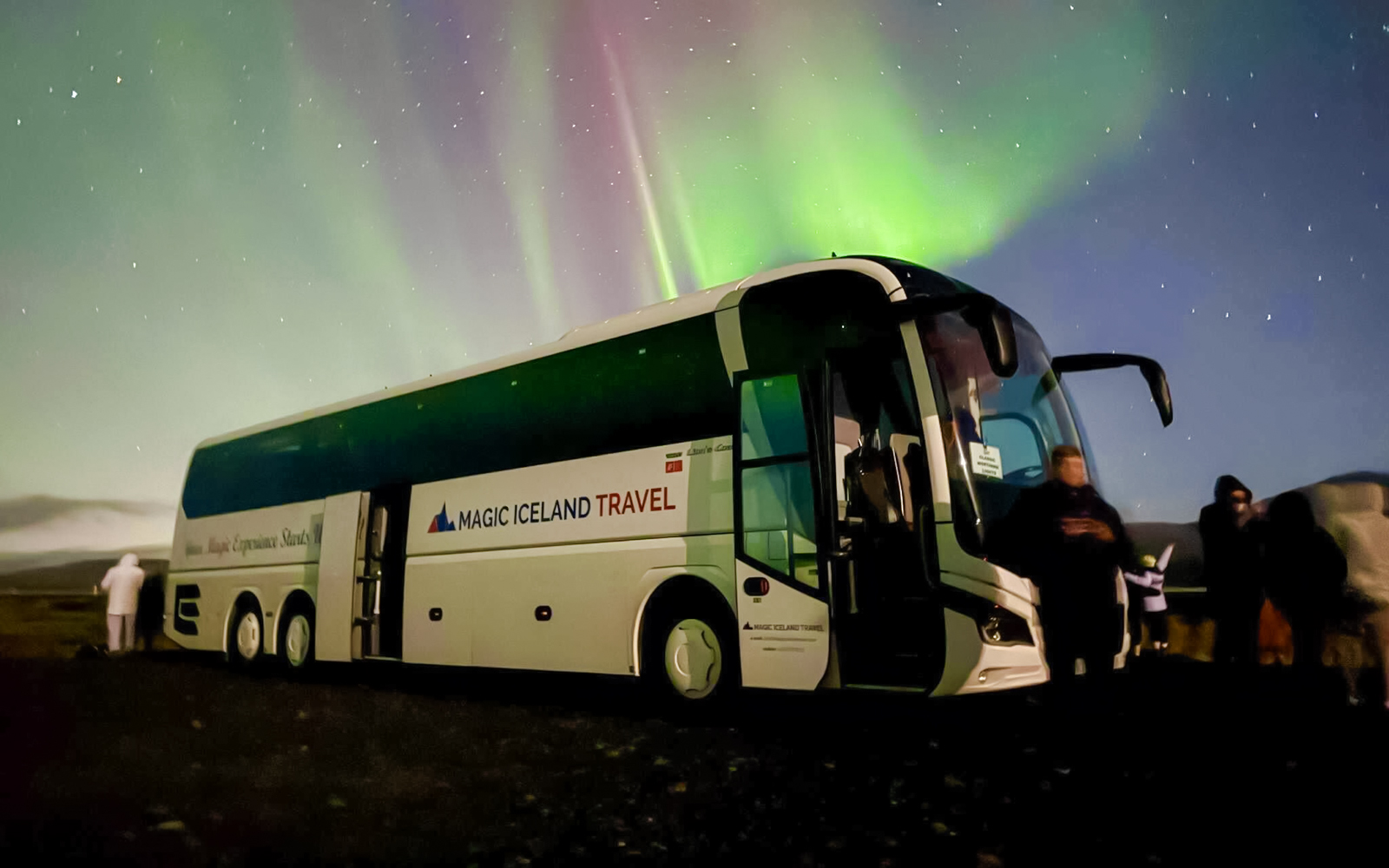 Coach parked under Northern Lights near Reykjavik, Iceland.