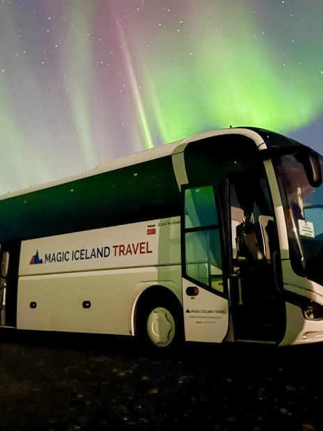 Coach parked under Northern Lights near Reykjavik, Iceland.