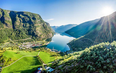 Flåm village nestled by Aurlandsfjord, surrounded by lush mountains and clear waters.