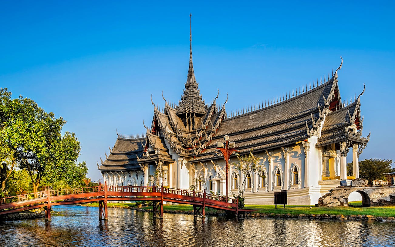 Sanphet Prasat Palace with ornate roof and bridge in Ancient City Park, Thailand.