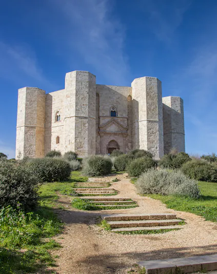 Castel del Monte in Italy with stone path leading to the entrance.