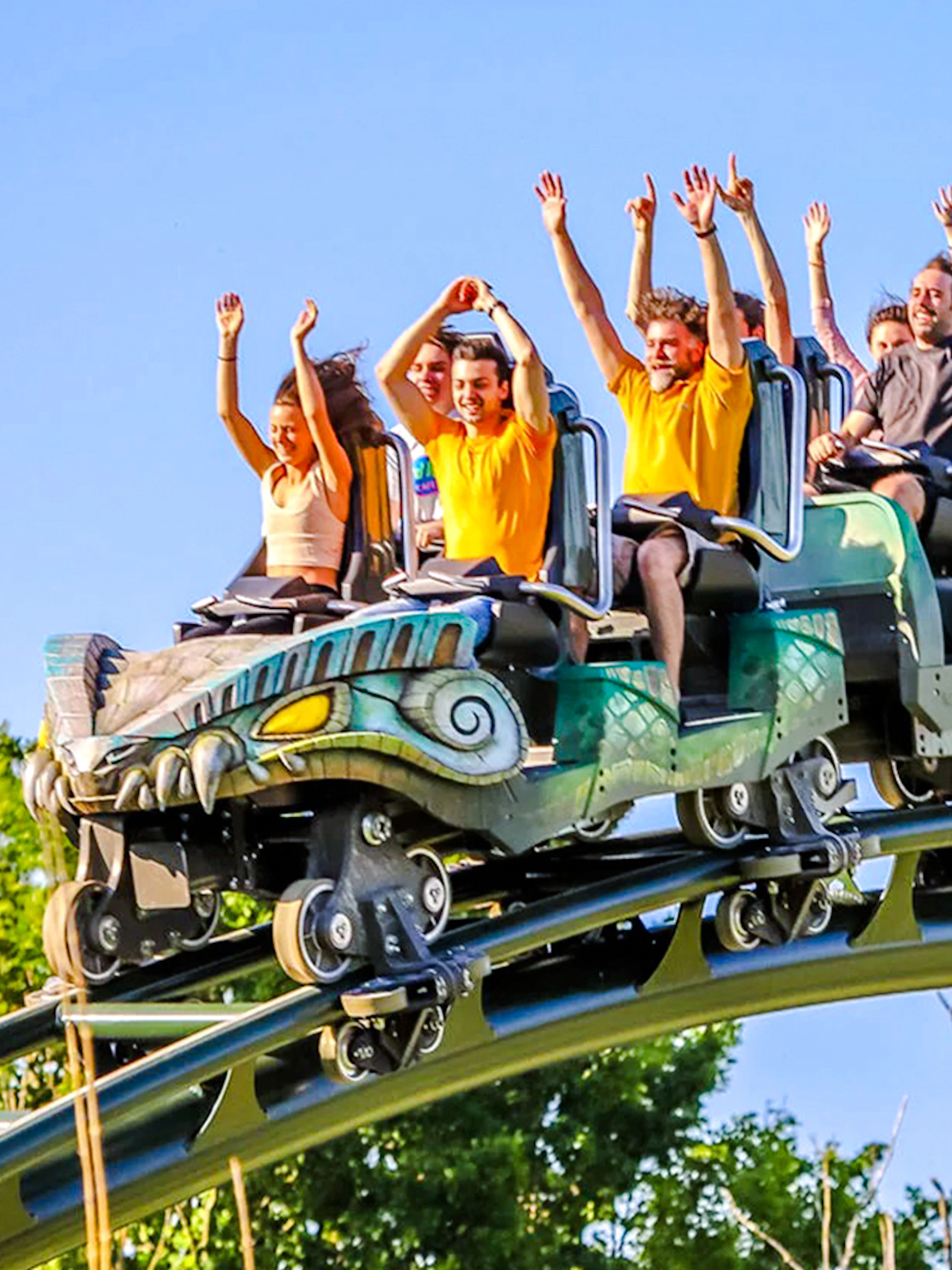 Kondaa roller coaster with riders raising hands on a sunny day.