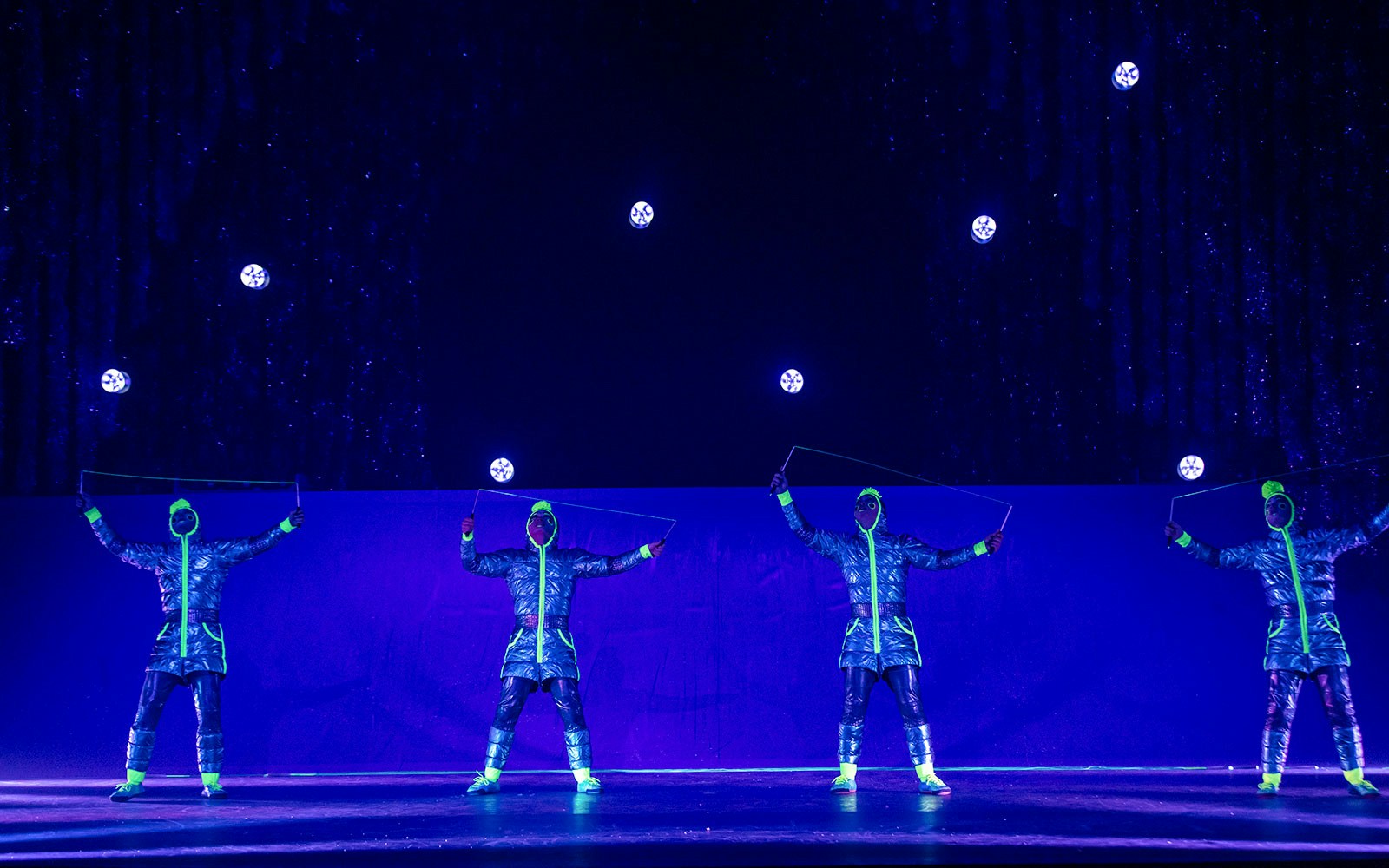 Performers in neon costumes juggling glowing balls in Cirque du Soleil 'Twas The Night Before show.