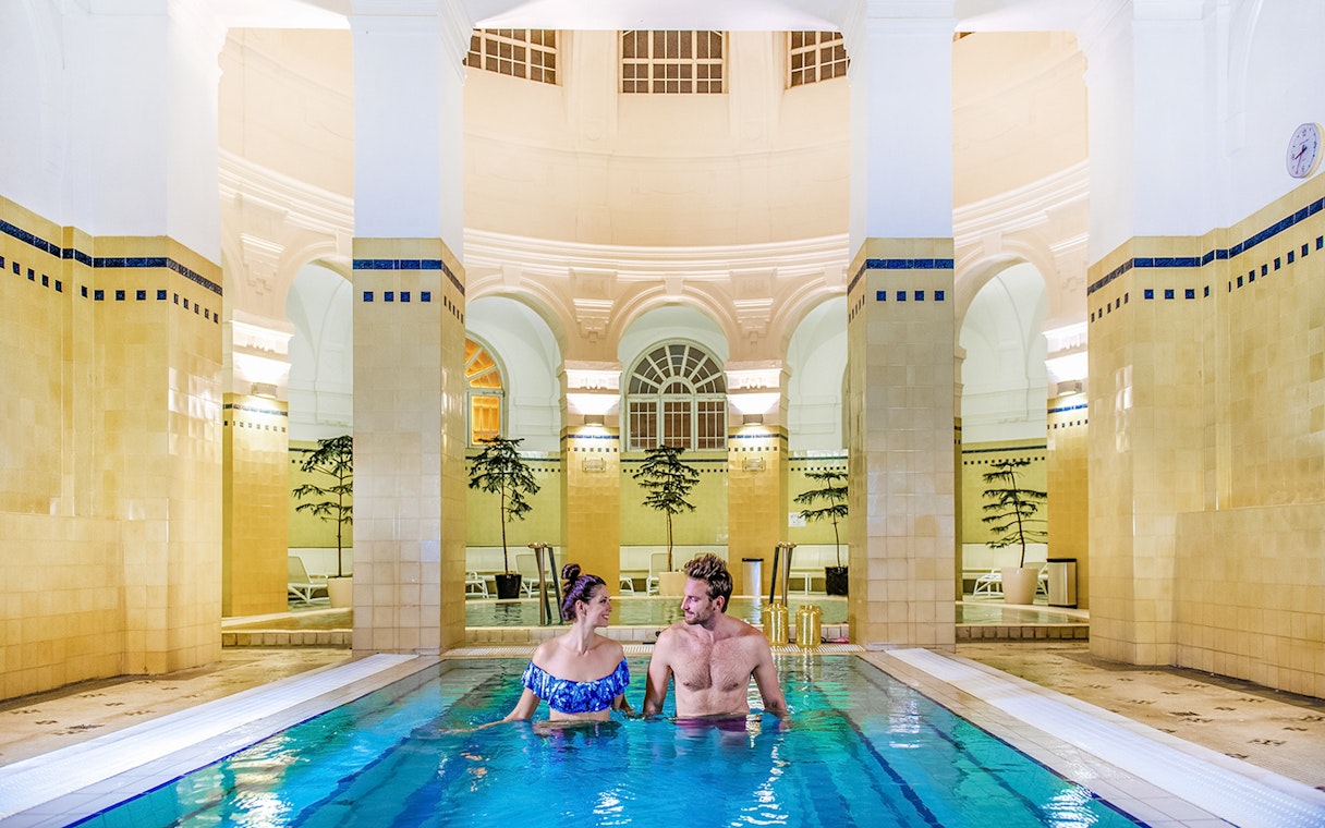 Guests relaxing in thermal pools at Szechenyi Bath's Premium Day Spa, Budapest.