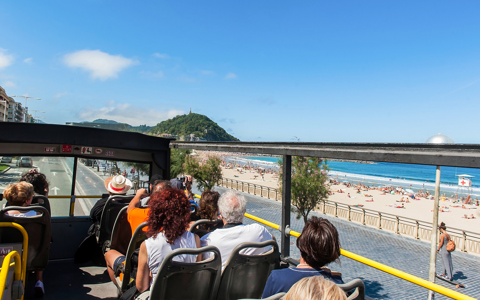 Open-top bus tour along La Concha Beach in San Sebastian, Spain.