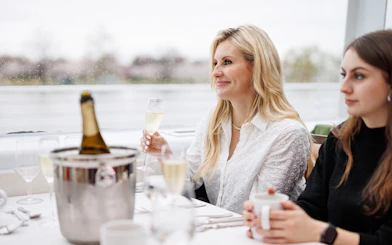 Guests enjoying drinks at a table on the Premier Bottomless Mimosa Brunch Cruise, Washington DC.