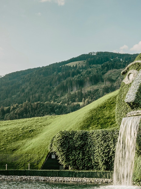 Giant grass-covered head with waterfall at Swarovski Crystal Worlds, Austria.