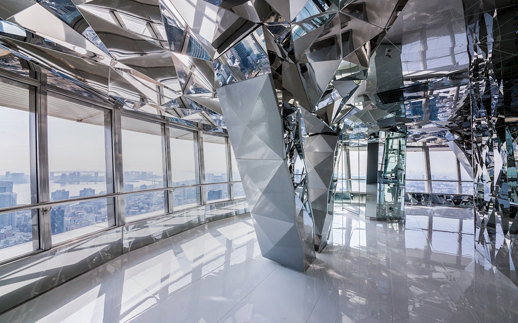 Upper deck of Tokyo Tower with mirrored interior and city view.
