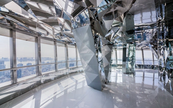 Upper deck of Tokyo Tower with mirrored interior and city view.