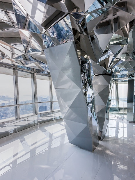 Upper deck of Tokyo Tower with mirrored interior and city view.