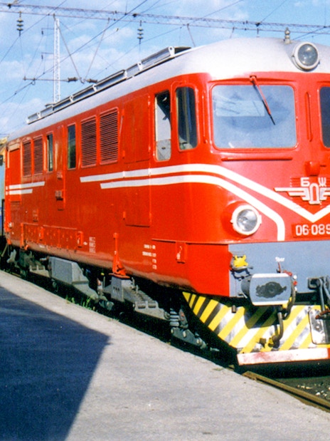 Red and blue train at a station, representing Eurail Global Flexible Pass with 1st Class Seats.