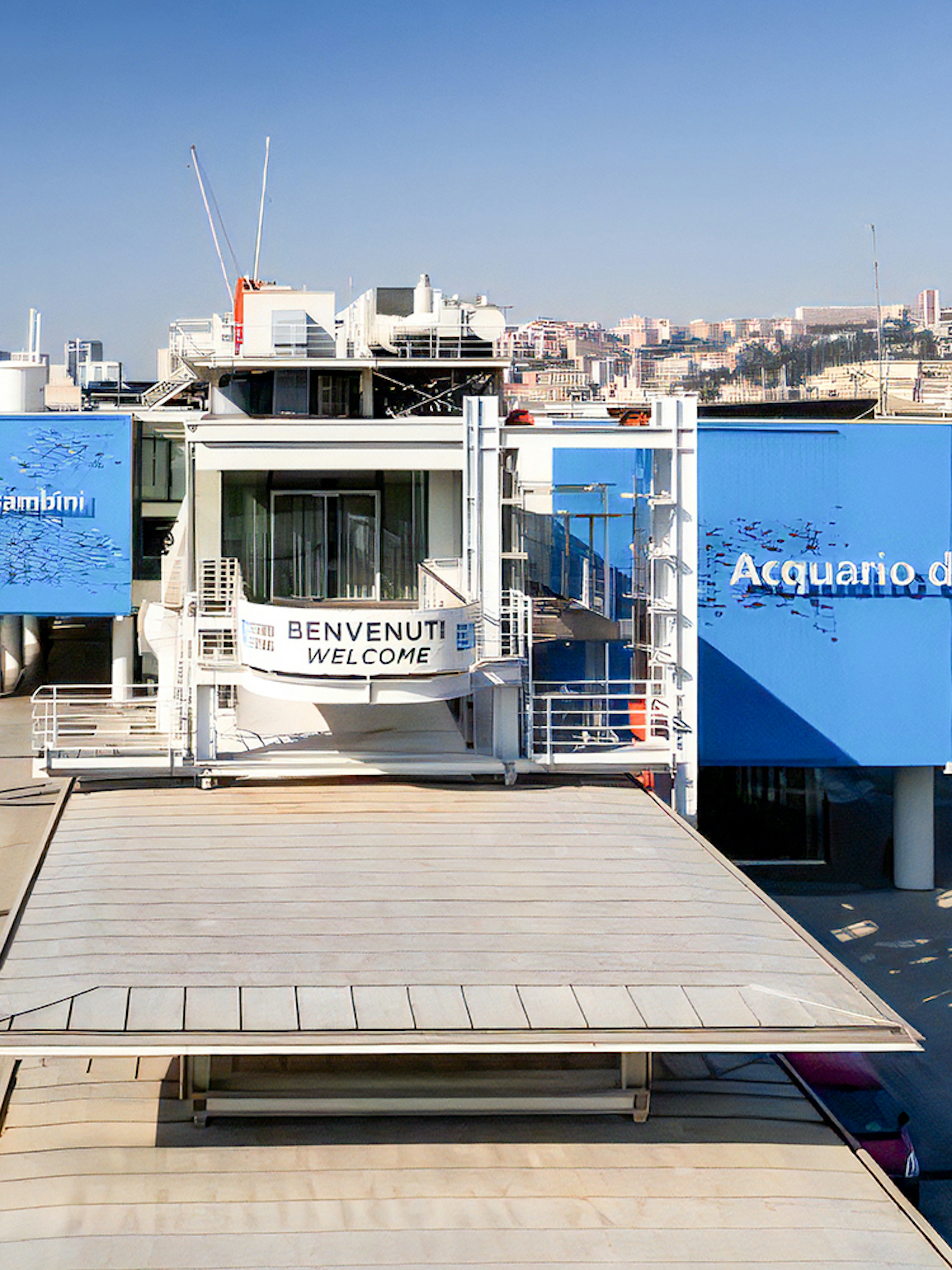 Exterior view of Aquarium of Genoa and City of Kids entrance, with nearby harbor and cityscape.