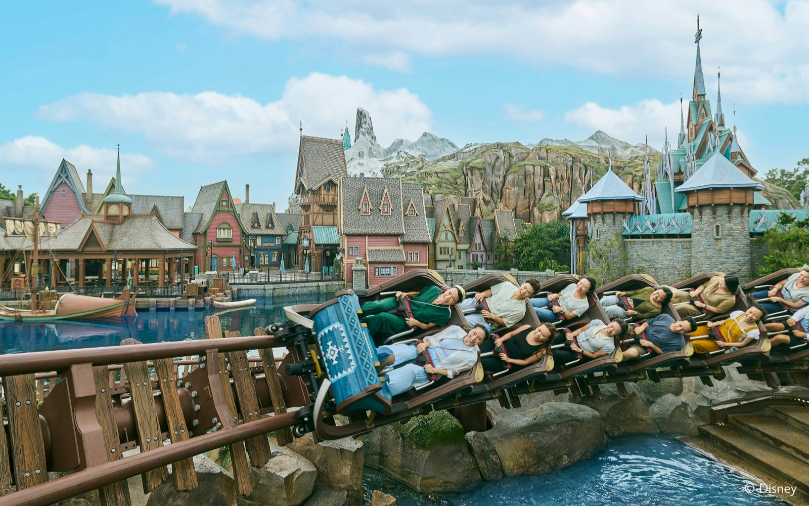 Roller coaster at Frozen Ever After, Disneyland Hong Kong, with riders passing Arendelle village.