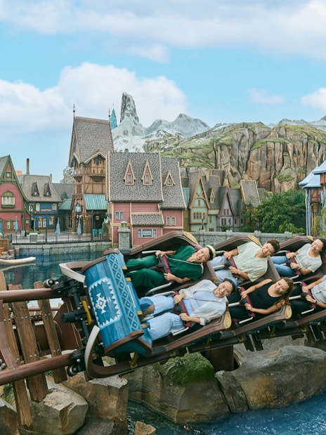 Roller coaster at Frozen Ever After, Disneyland Hong Kong, with riders passing Arendelle village.