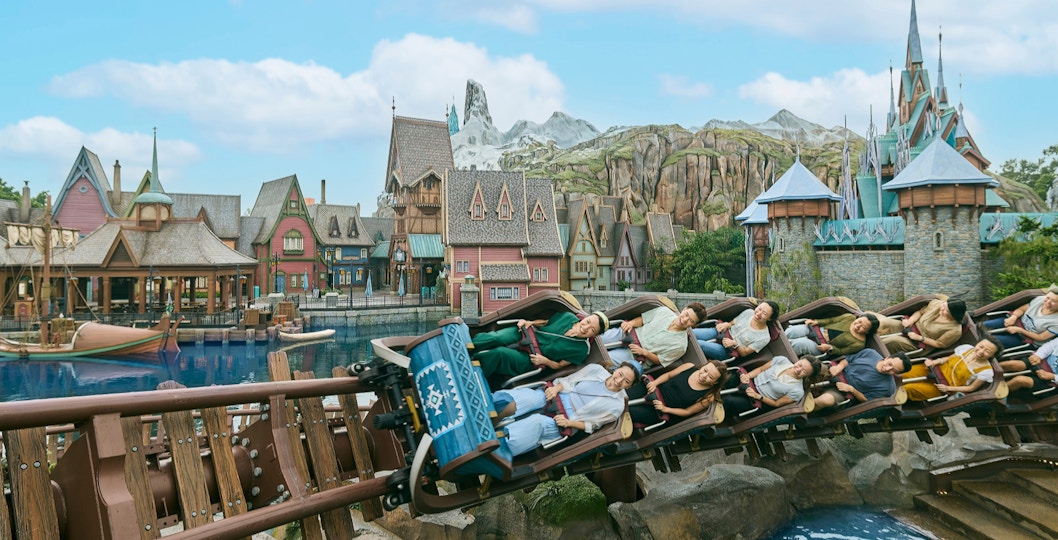 Roller coaster at Frozen Ever After, Disneyland Hong Kong, with riders passing Arendelle village.