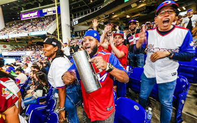 Fans cheering at a Miami Marlins game in a lively stadium atmosphere.