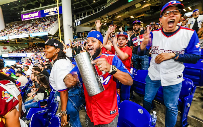 Fans cheering at a Miami Marlins game in a lively stadium atmosphere.