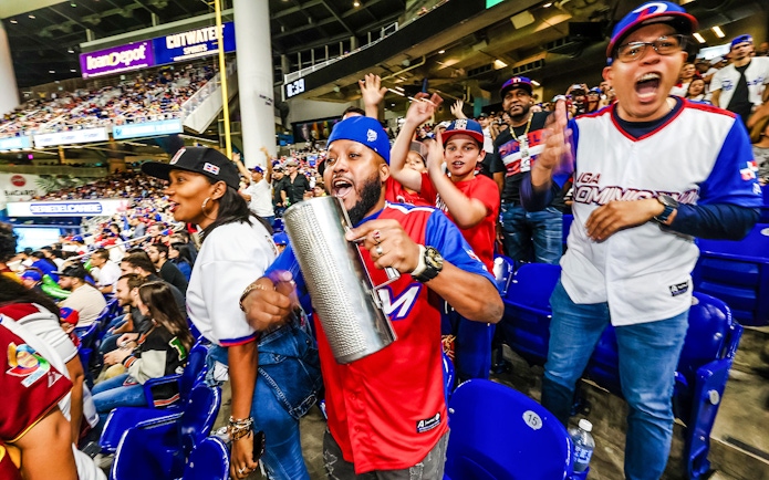Fans cheering at a Miami Marlins game in a lively stadium atmosphere.