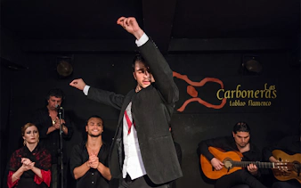 Flamenco dancer performing at Tablao Las Carboneras with musicians in Madrid.