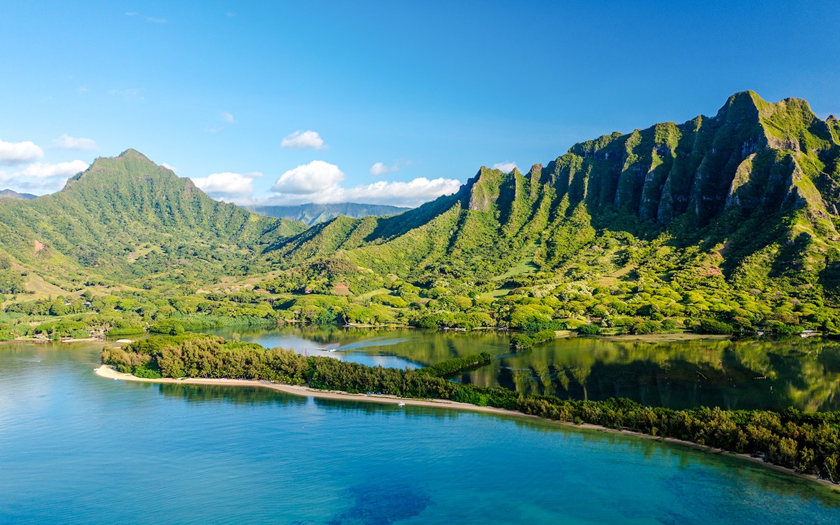 Kualoa Ranch landscape with lush green mountains and coastal waters, Oahu, Hawaii.