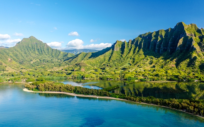 Kualoa Ranch landscape with lush green mountains and coastal waters, Oahu, Hawaii.