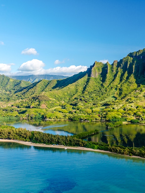 Kualoa Ranch landscape with lush green mountains and coastal waters, Oahu, Hawaii.