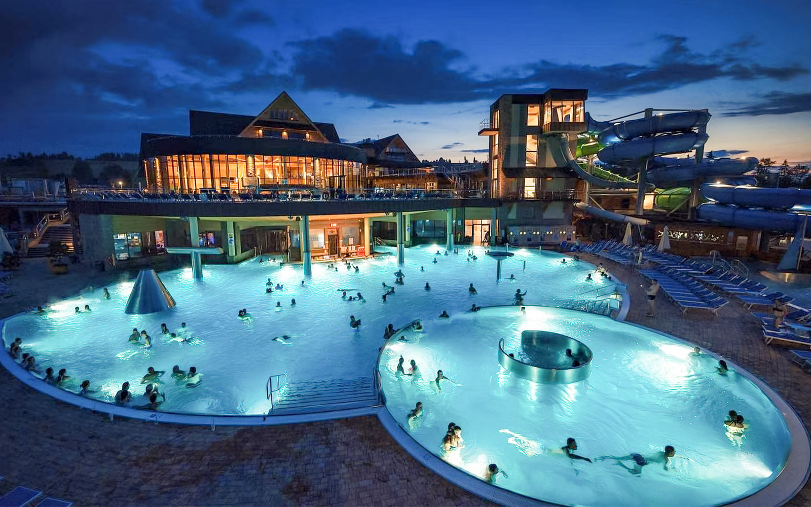 Thermal pools at night with people swimming, Zakopane tour experience.