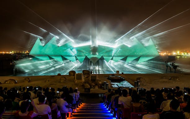 Wings of Time light show at Sentosa, Singapore, with audience watching vibrant projections.