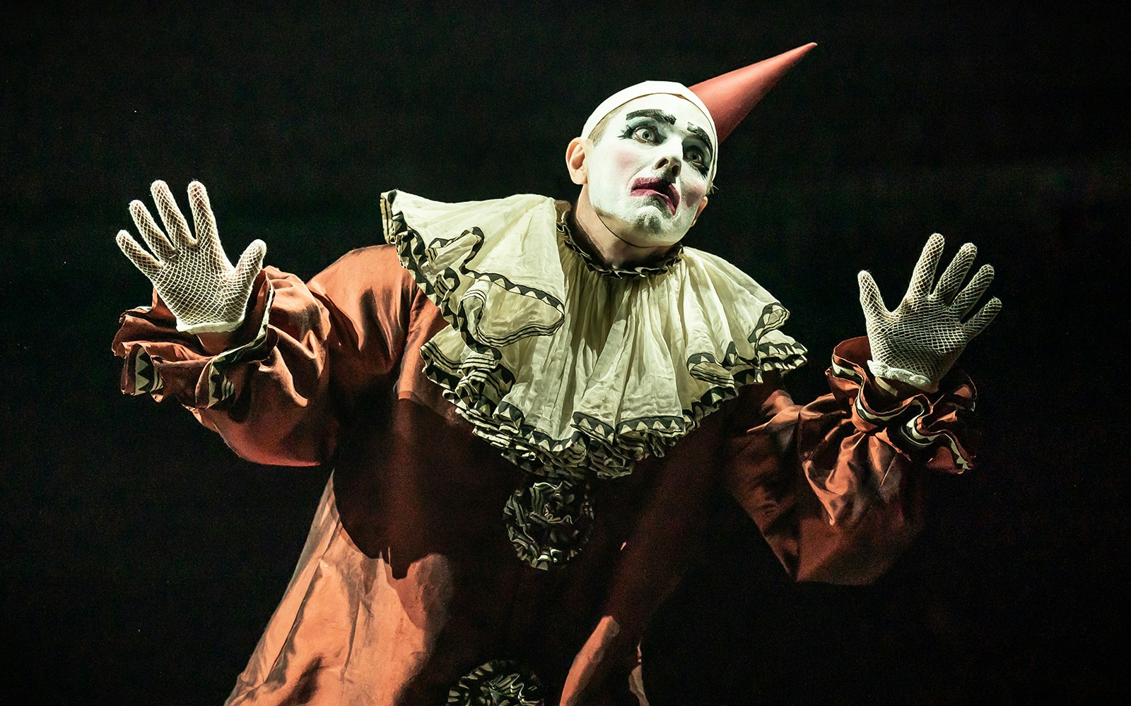 Performer in clown costume during a cabaret show.