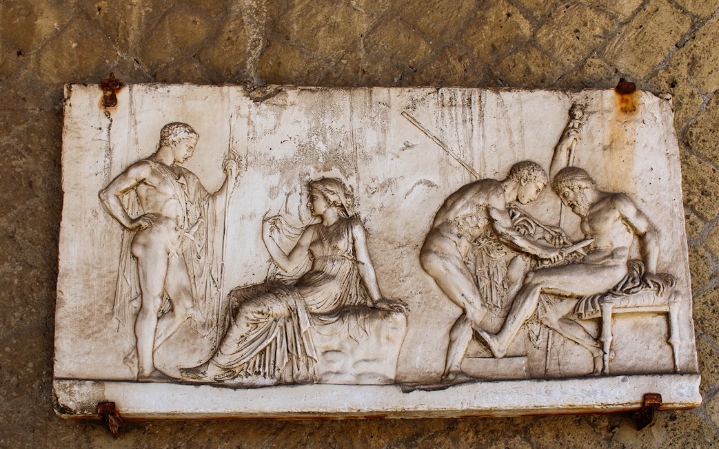 Bas-relief depicting ancient figures in Herculanum, Italy.